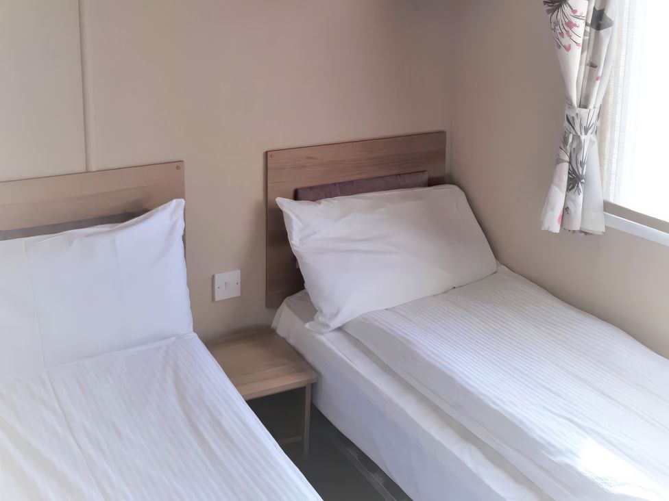 A bedroom with two single beds and a window at Par Sands Holiday Park - 6388, Par