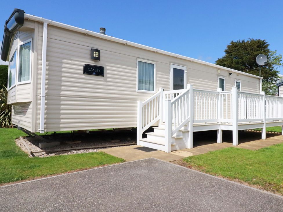 A mobile home with a deck and steps at The Oakley in Par