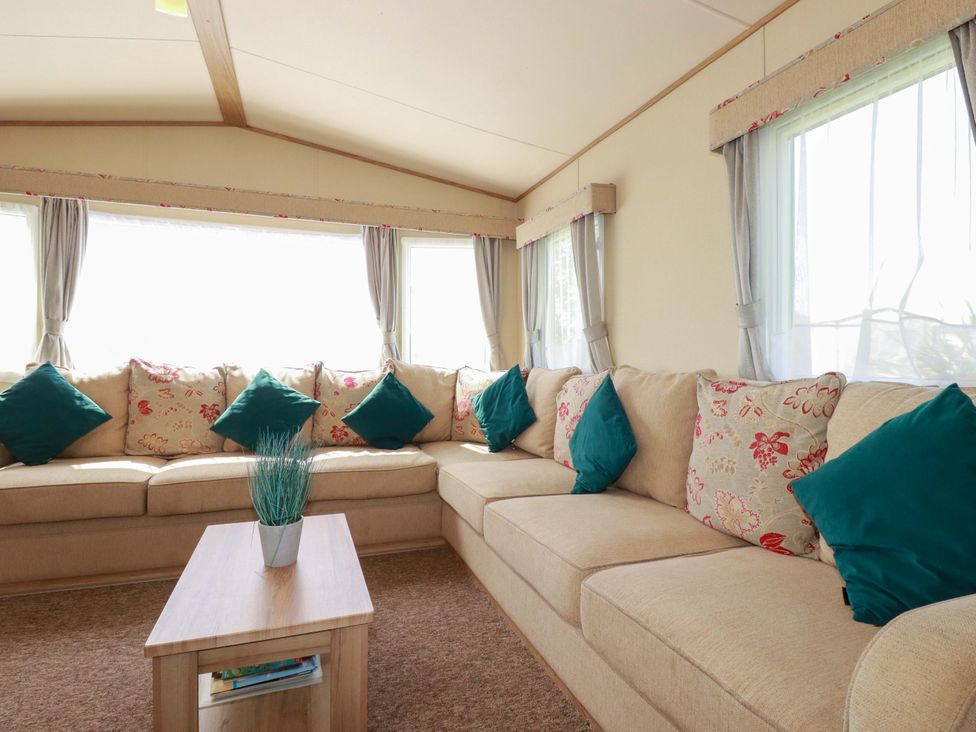 A snug with a sectional sofa and coffee table at The Oakley in Par