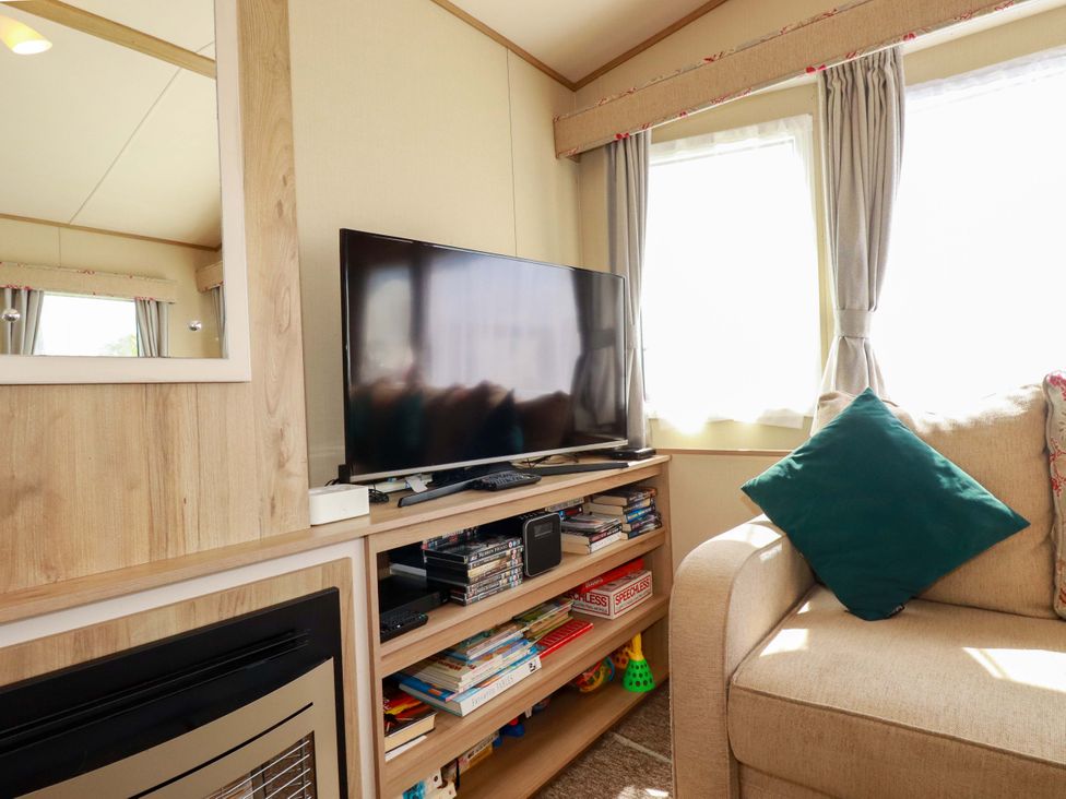A living room with a television and entertainment unit at The Oakley in Par