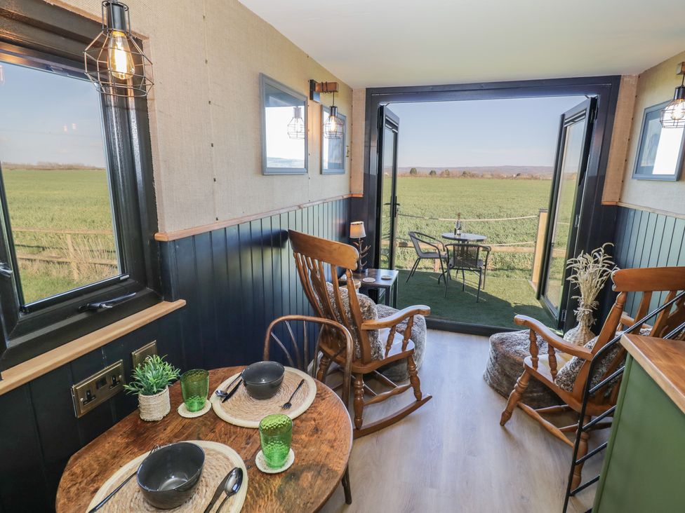 A living room with rocking chairs and a view of fields at GiGi's Horsebox in Evesham