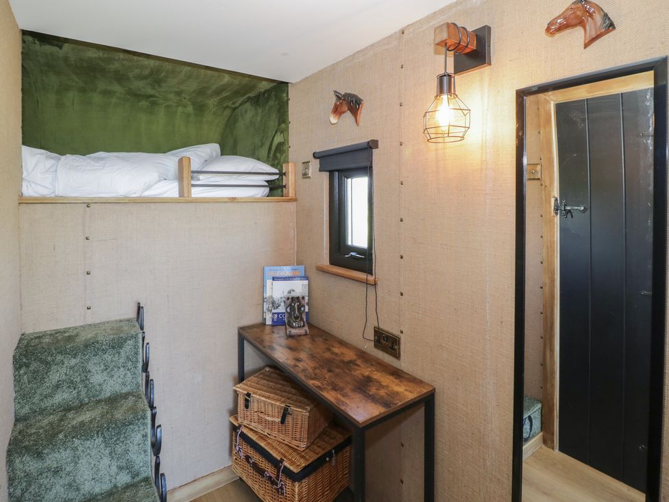 A bedroom with a bunk bed and a desk at GiGi's Horsebox Evesham