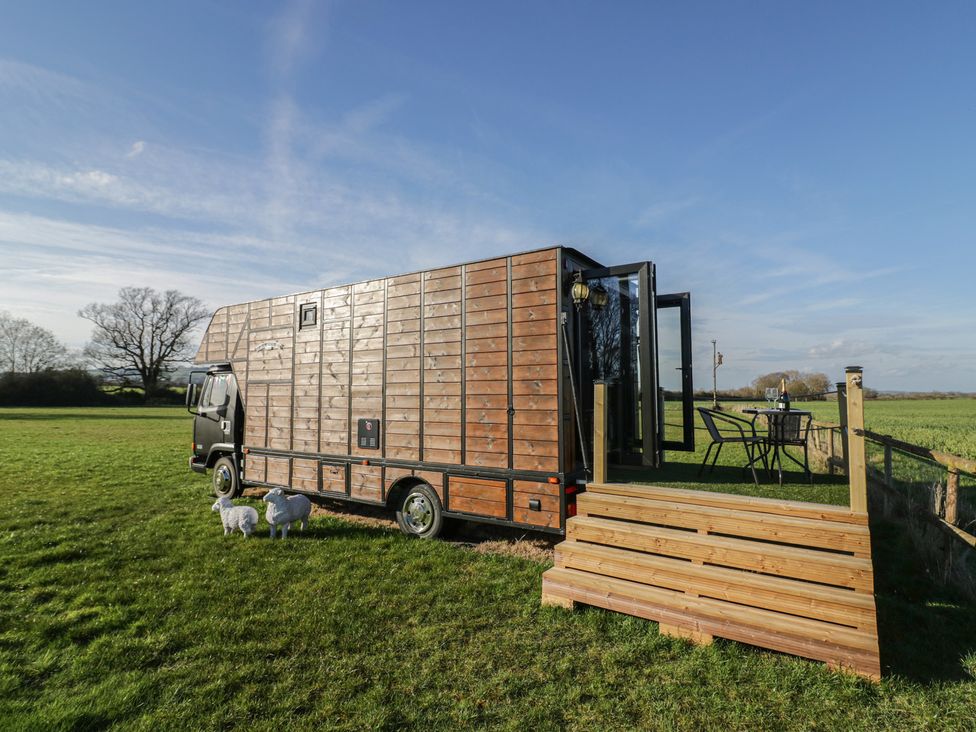 A horsebox with a table and chairs in front at GiGi's Horsebox in Evesham