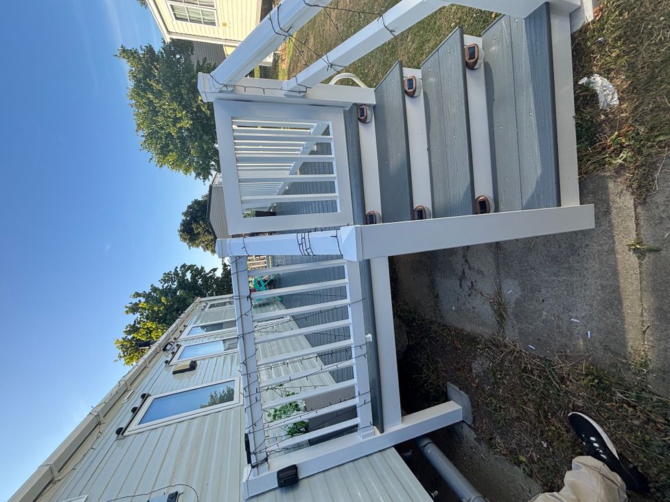 A set of stairs with a railing leading to a house in an outdoor area
