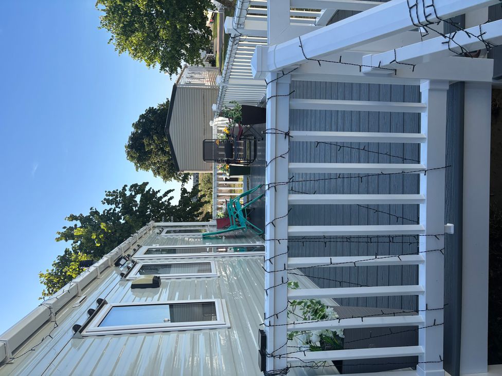 An outdoor deck with chairs and planters at a property