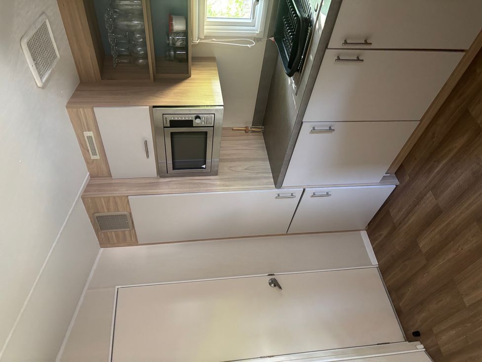 A kitchen with cabinets and a microwave at the property