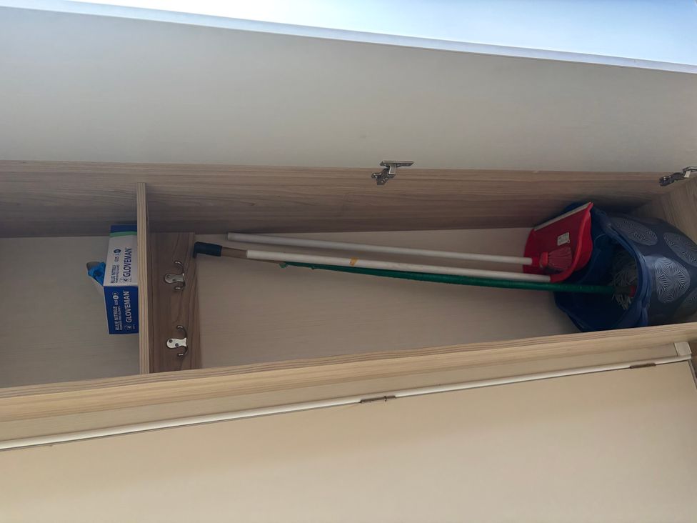 A utility room with a cleaning mop and bucket on a shelf at the property