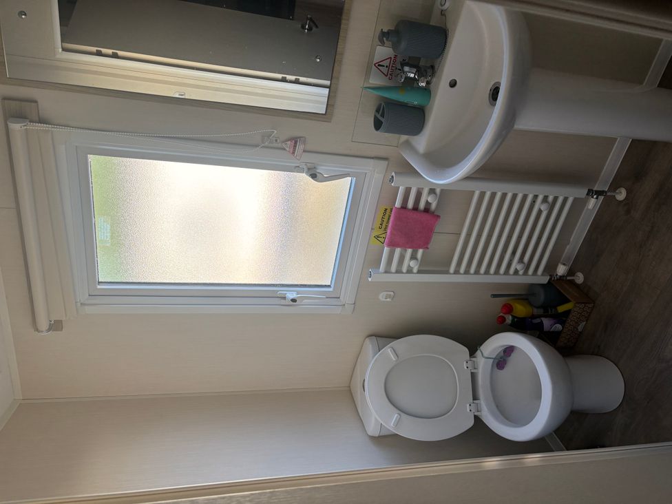 A bathroom with a sink, toilet, and window at 
