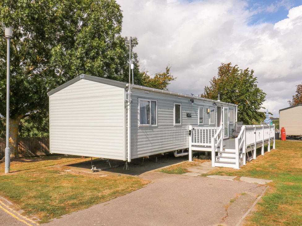 A caravan with steps and parking area at Singh and Leite Family Caravan in St. Osyth