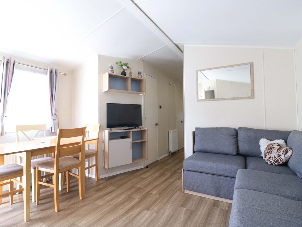A living room with a dining table and sofa at Singh and Leite Family Caravan St. Osyth