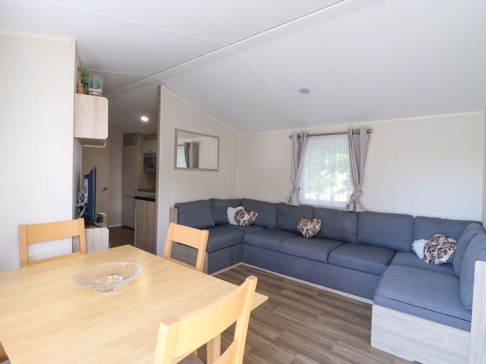 A living room with a sofa and table at Singh and Leite Family Caravan St. Osyth
