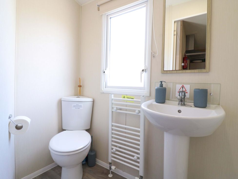 A bathroom with a toilet and sink at Singh and Leite Family Caravan St. Osyth