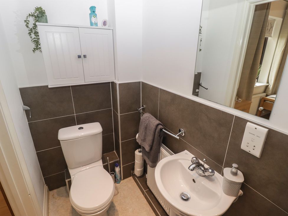 A bathroom with a toilet and sink at Awel y Môr Burry Port