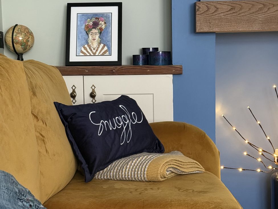 A living room with a sofa and artwork at Portknockie Cottage in Buckie