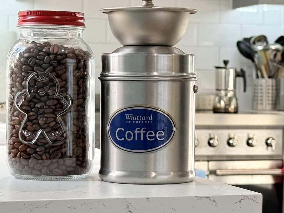A coffee grinder and jar of coffee beans on a kitchen countertop at Portknockie Cottage in Buckie