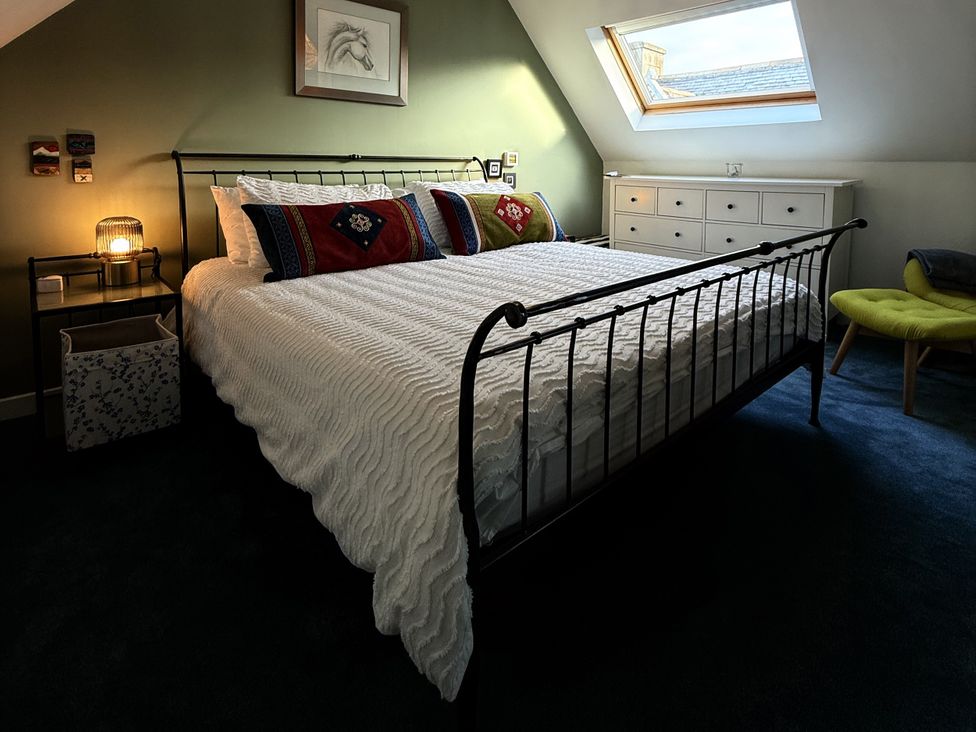 A bedroom with a bed and side table at Portknockie Cottage in Buckie