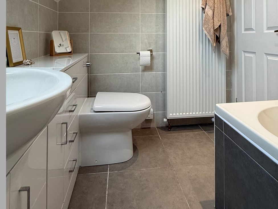A bathroom with a toilet, wash basin, and bath tub at Portknockie Cottage in Buckie