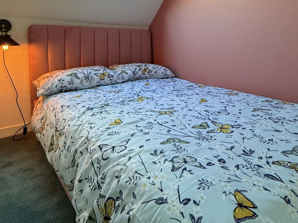 A bedroom with a bed and a lamp at Portknockie Cottage in Buckie