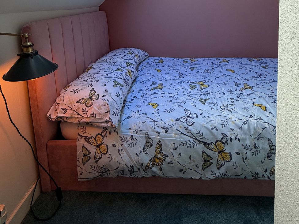 A bedroom with a bed and bedside lamp at Portknockie Cottage in Buckie