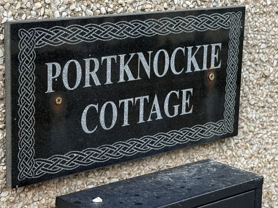 A nameplate displaying Portknockie Cottage with a mailbox at Portknockie Cottage in Buckie