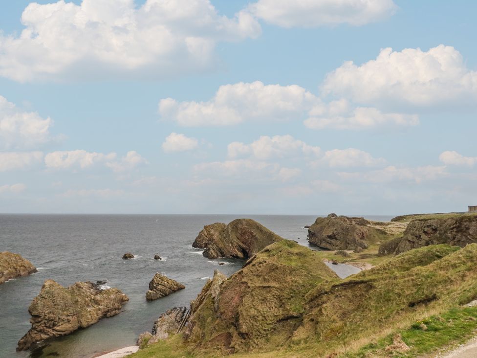 A coastal view with rocks and sea at Portknockie Cottage in Portknockie