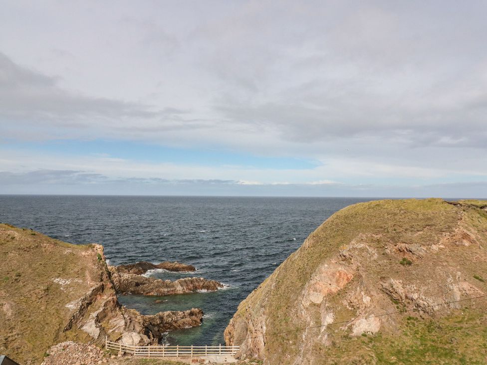 A seaside view of cliffs and water at Portknockie Cottage in Portknockie