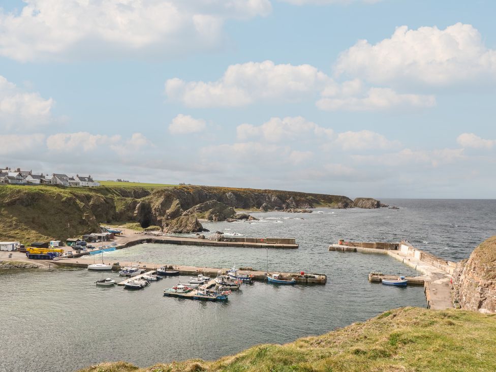 A harbor with boats and houses in Portknockie Cottage Portknockie