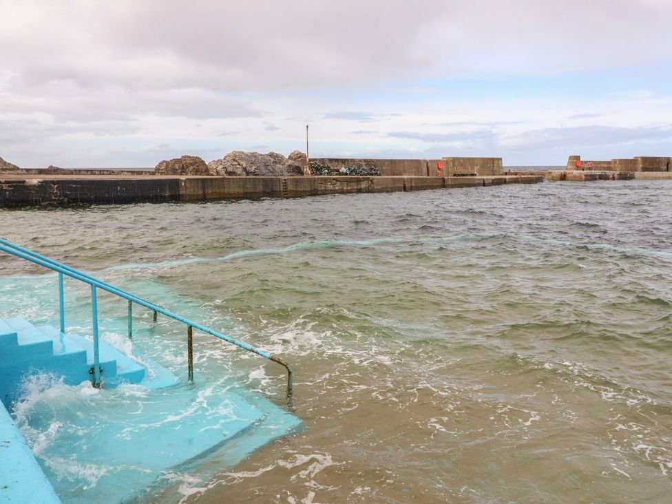 A pier with stairs leading into the water at Portknockie Cottage in Portknockie
