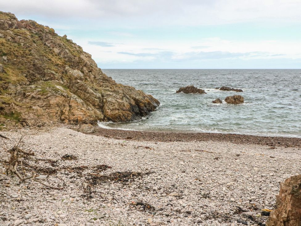 A beach area with pebbles and rocks at Portknockie Cottage in Portknockie