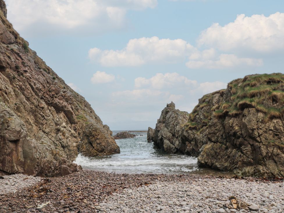 A beach view with rocks and water at Portknockie Cottage Portknockie