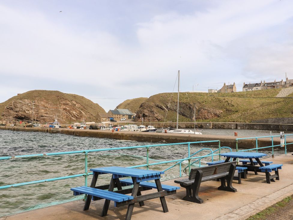 A harbor with boats and seating at Portknockie Cottage in Portknockie