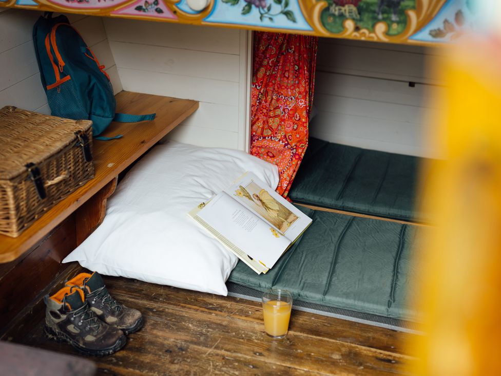 A cozy nook with a pillow, boots, and a book at Goldfinch in Launceston