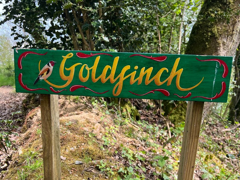 A sign with the name Goldfinch and a bird illustration at Goldfinch in Panson Mill near Ashwater