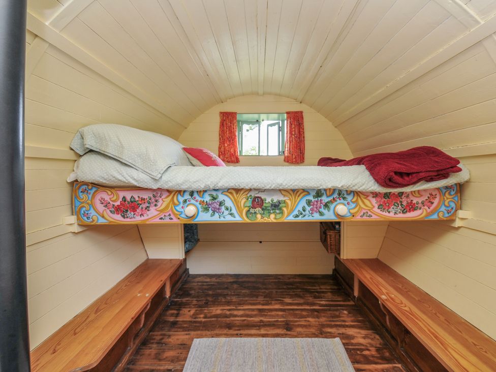 A bedroom with a bed and window at Goldfinch in Panson Mill near Ashwater