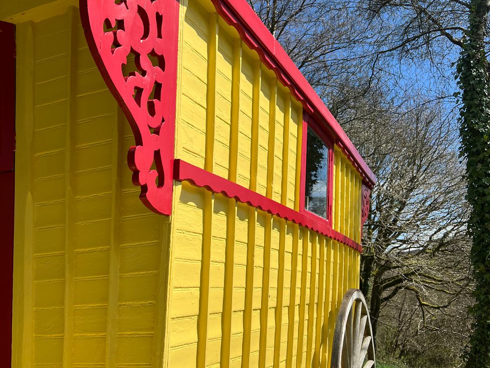 A yellow wooden structure with red trim and a window in Prudence Launceston