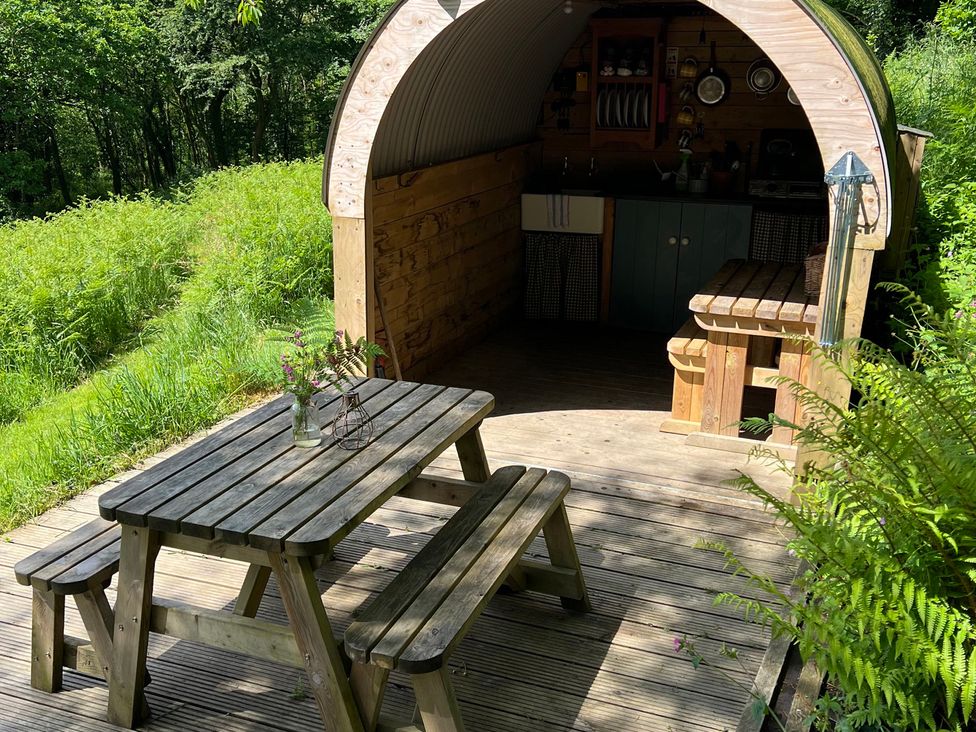 An outdoor kitchen with a table and benches at Prudence in Launceston