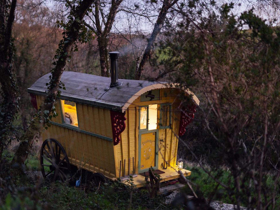 A yellow caravan with a chimney in a rural setting at Prudence in Launceston