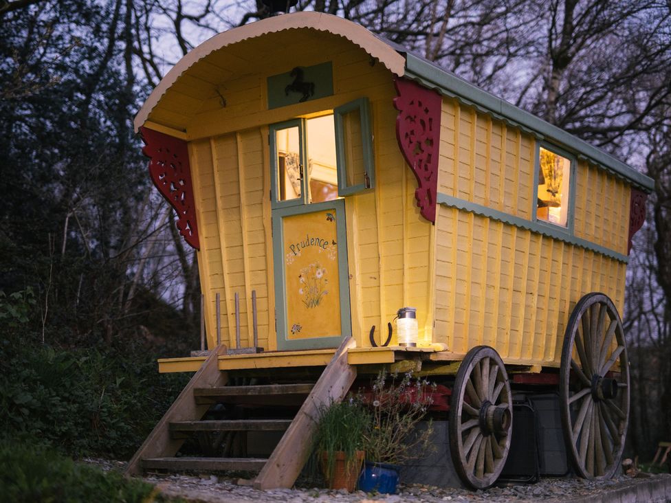 A yellow caravan with wheels and steps outside at Prudence in Launceston