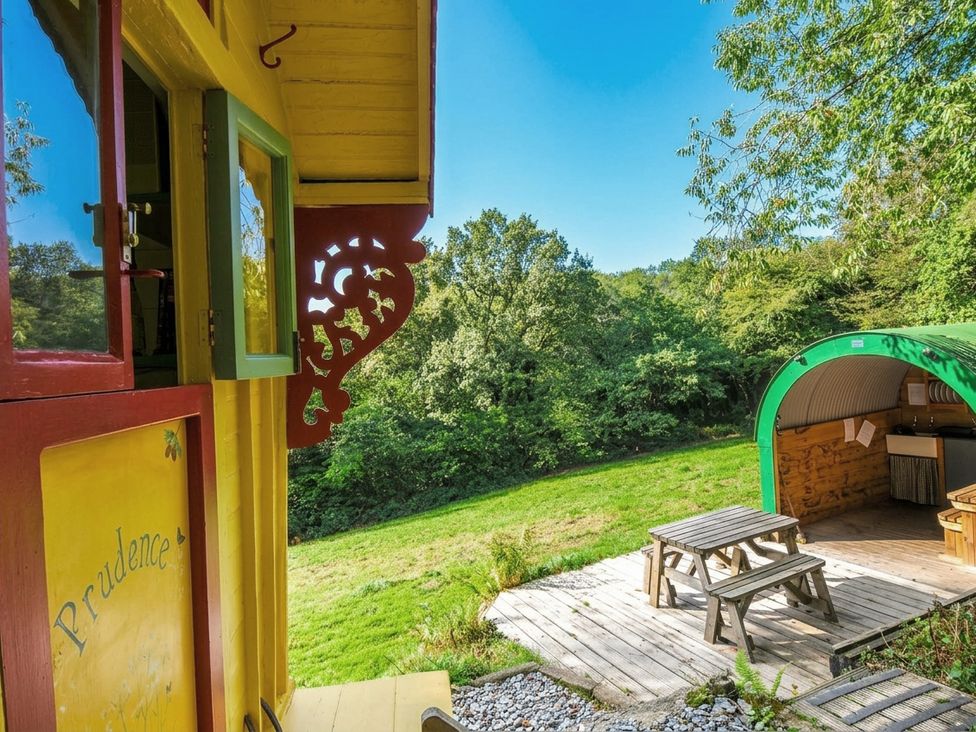 An outdoor area with a table and grill at Prudence in Panson Mill near Ashwater