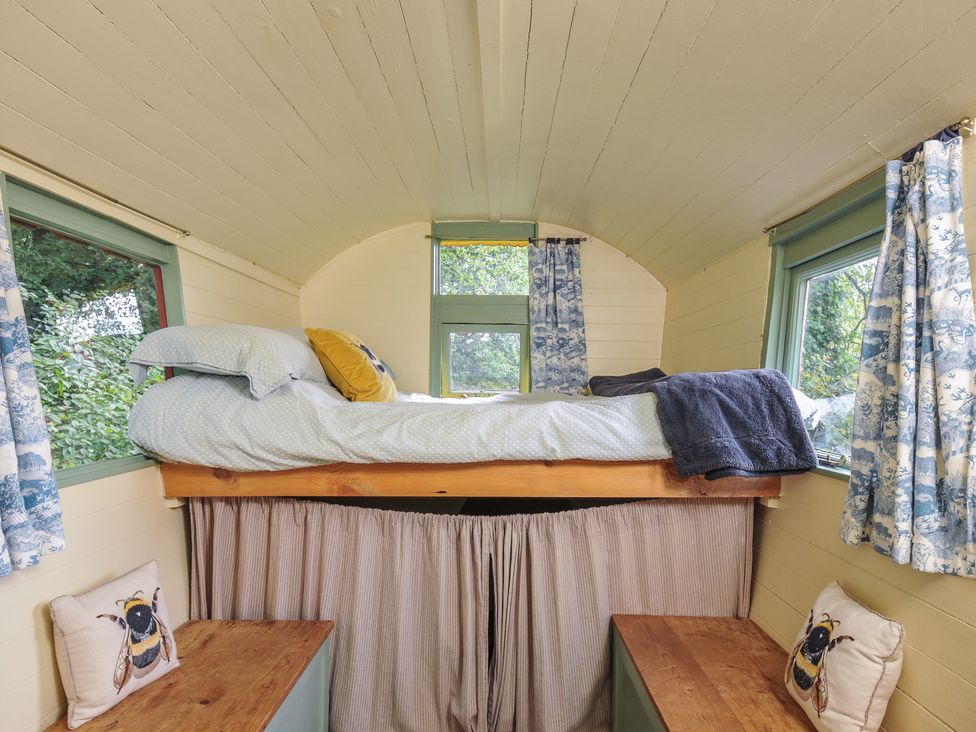 A bedroom with a loft bed and windows at Prudence in Panson Mill near Ashwater