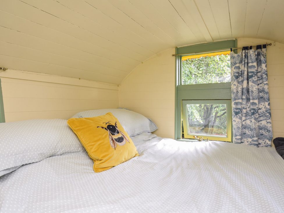 A bedroom with bed and decorative pillow at Prudence Panson Mill near Ashwater