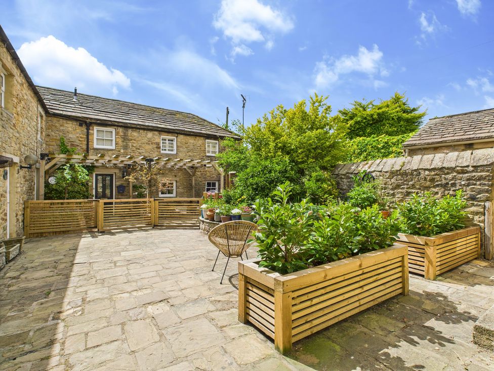 A courtyard with planters and a stone wall at 17C King Street Barnard Castle