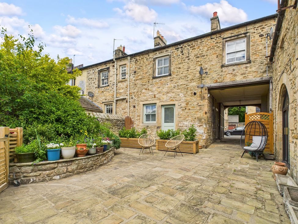 A garden area with stone wall and outdoor seating at 17C King Street Barnard Castle