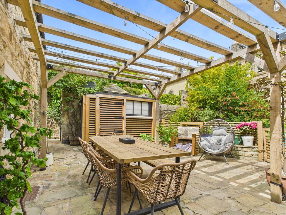 A garden with a wooden table and chairs at 17C King Street in Barnard Castle