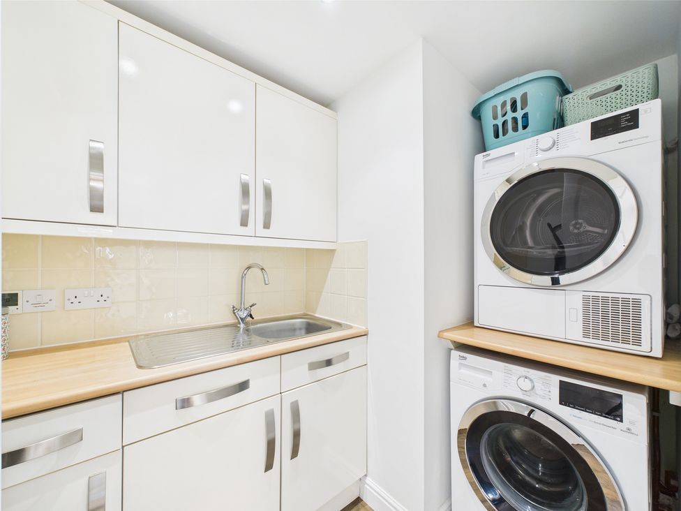 A laundry room with a sink and appliances at 17C King Street Barnard Castle