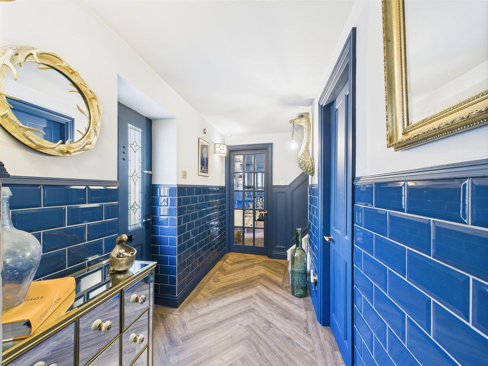 A hallway with blue tiles and a mirror at 17C King Street Barnard Castle