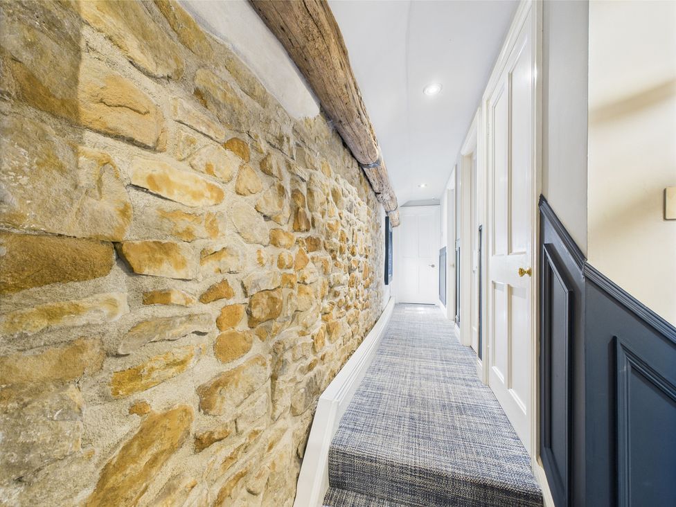 A hallway with stone wall and carpet at 17C King Street Barnard Castle
