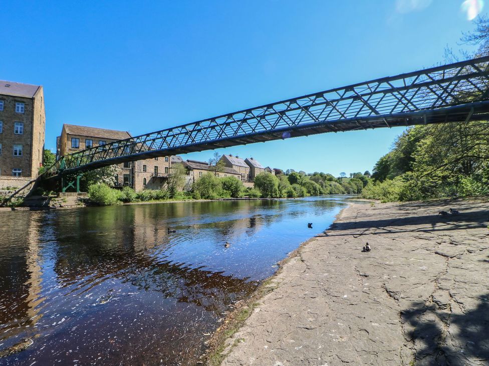 A river with a bridge and buildings along the bank at 17C King Street Barnard Castle