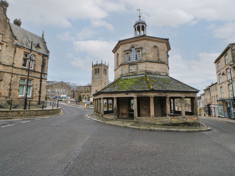 A street view with a stone structure and buildings at 17C King Street Barnard Castle