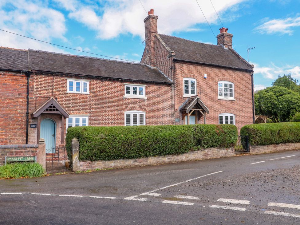 A house with brick exterior and hedge on Marl Pit Lane